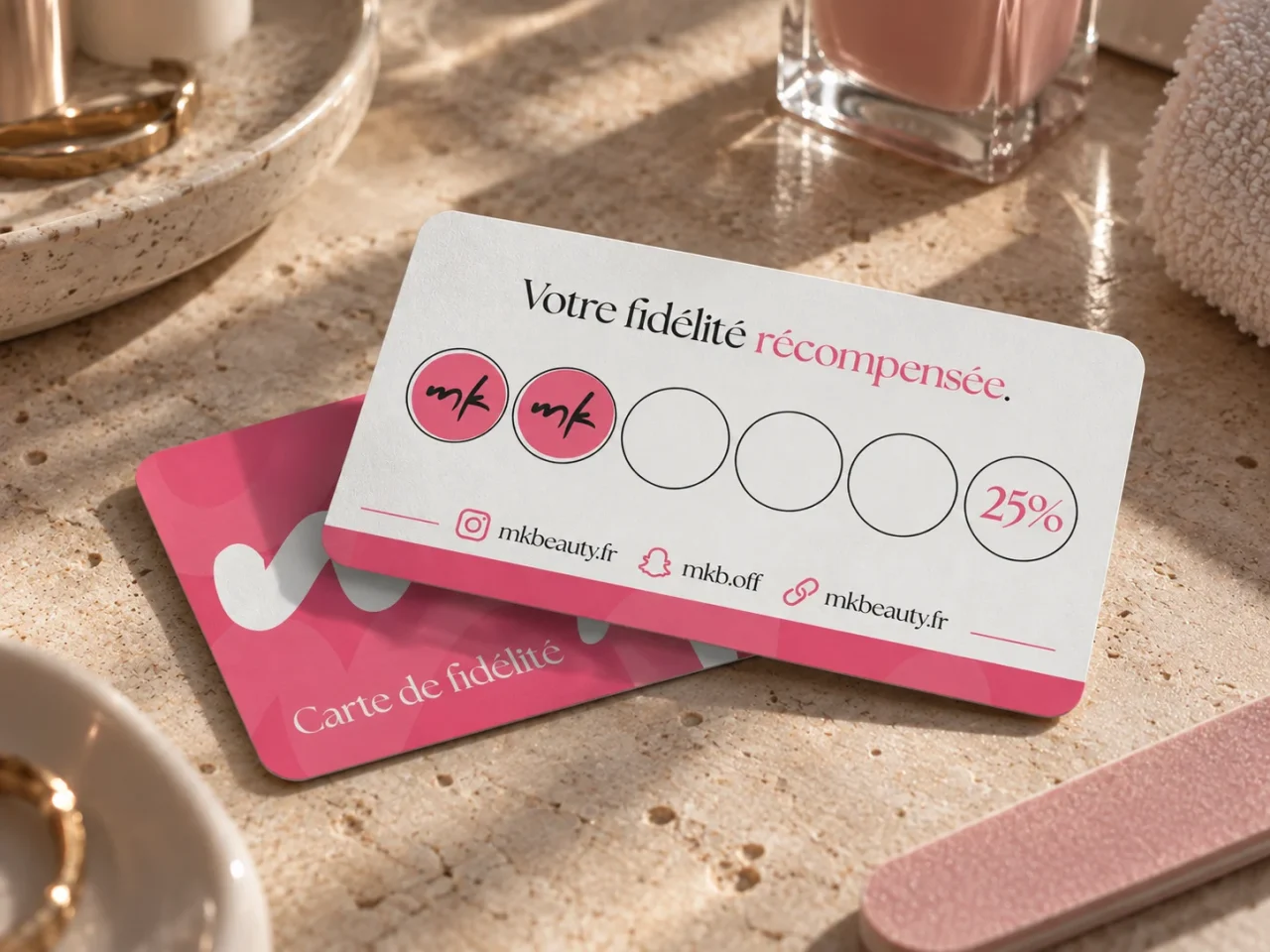 Mise en situation de cartes de fidélité roses et blanches réalisées pour l’identité de MK Beauty.